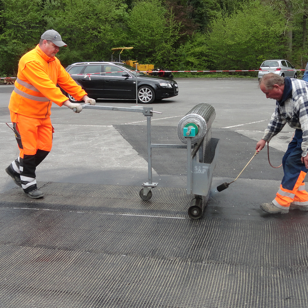 Manual application of S&P asphalt reinforcement (local surfaces)