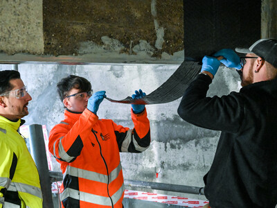 The experts apply the first layer of carbon fibre fabric for the shear reinforcement.