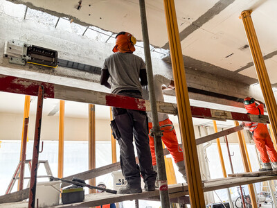 Applying the prestressed laminate to the side face of the concrete beam.