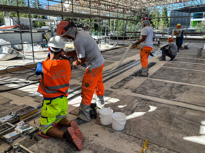 Cleaning and positioning of the third prestressed laminate on the top side of the central primary downstand beam.