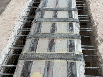 Top view of the shear strengthening that encircles the downstand beam through openings. Thanks to high‑pressure water‑jetting, the existing reinforcement was preserved.